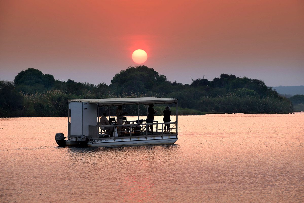 Victoria Falls Sunrise Cruise, where you'll witness the natural beauty of one of the world's most iconic waterfalls in the gentle morning light. Glide along the Zambezi River as the sun rises, casting a golden glow over the landscape, and take in panoramic views of Victoria Falls from a unique vantage point.